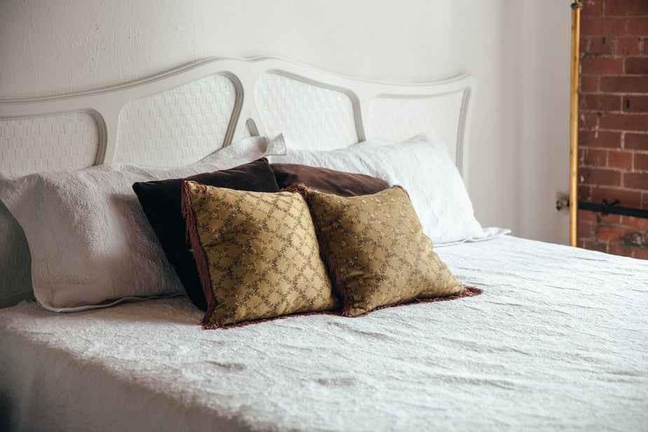 Comfortable bed with decorative pillows in a cozy setting
