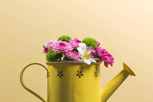 Yellow watering can filled with colorful flowers